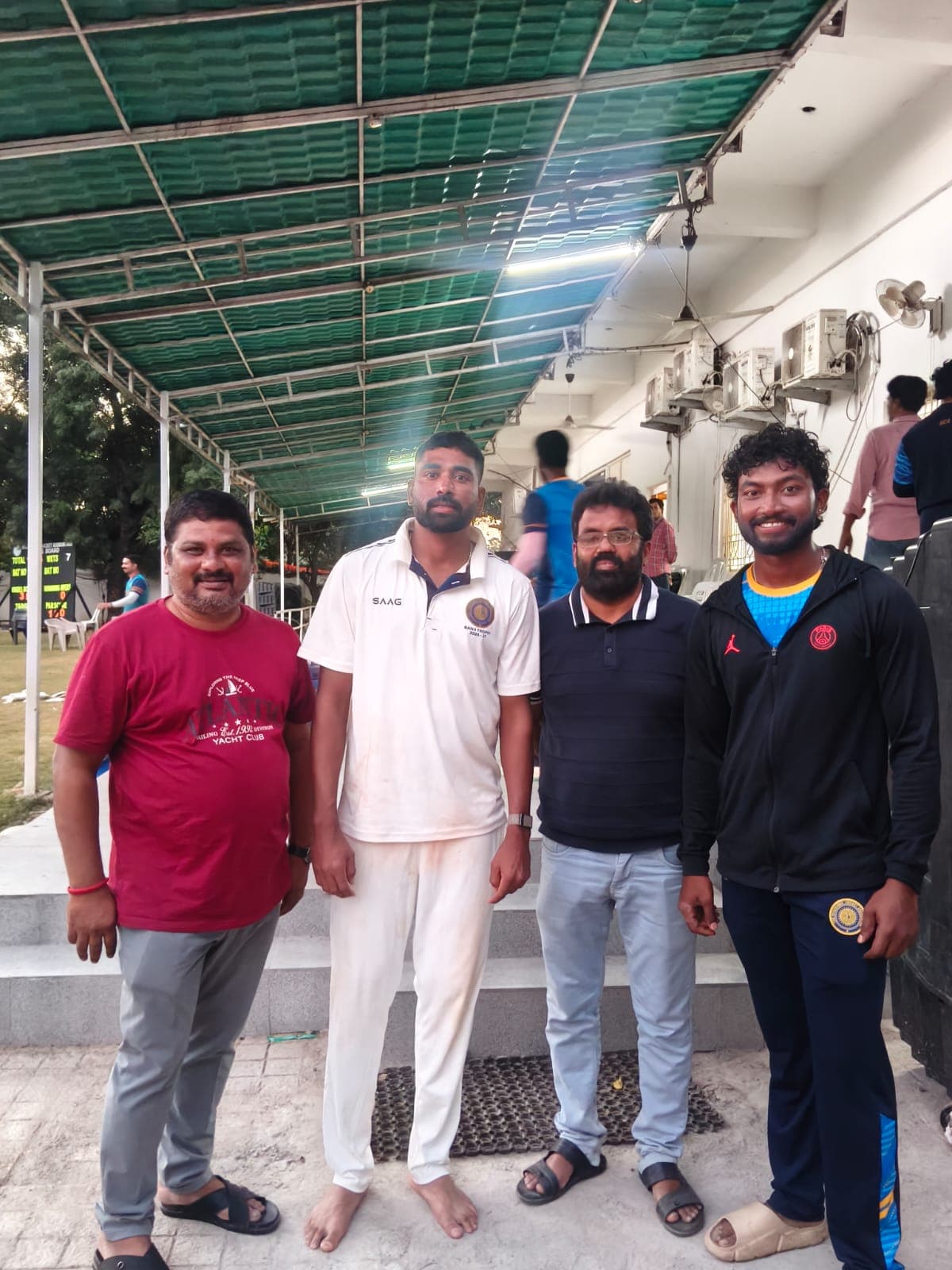 Staff members with cricket players at the stadium pavilion