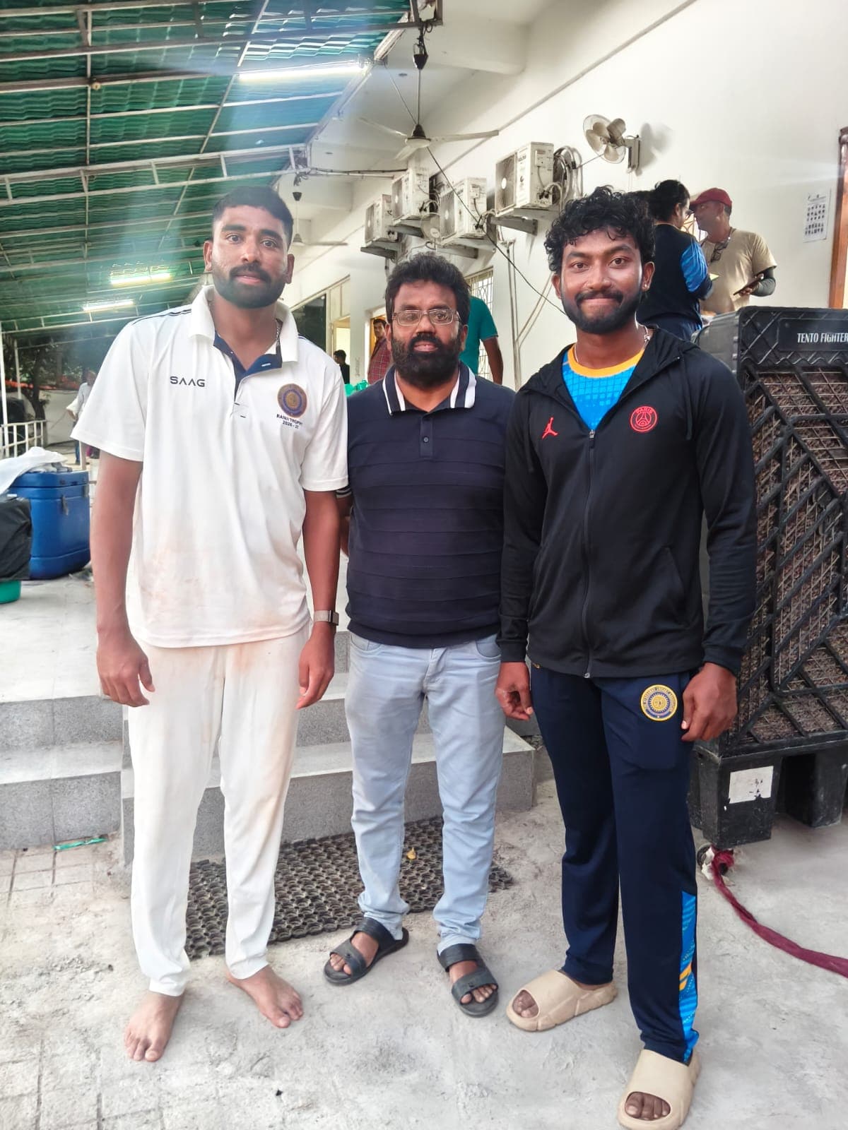 Three individuals standing together at the cricket ground
